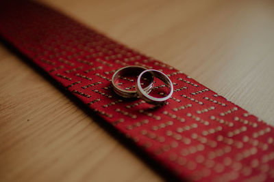 Close-up of wedding rings on necktie at table