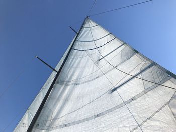 Low angle view of sailboat against clear blue sky