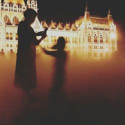 Woman in illuminated city at night