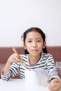 Portrait of a smiling young woman sitting at table