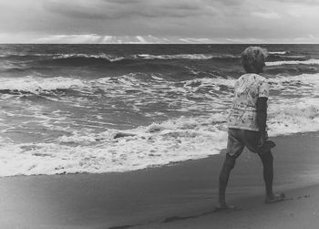 Rear view of boy playing on beach