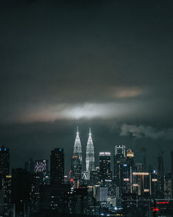 Illuminated cityscape against sky at night