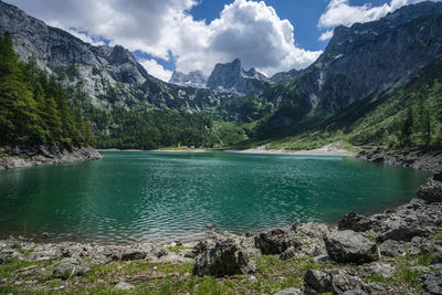 Scenic view of lake by mountains against sky