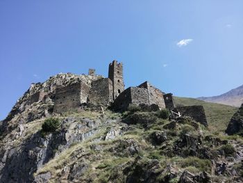 Low angle view of hill against blue sky