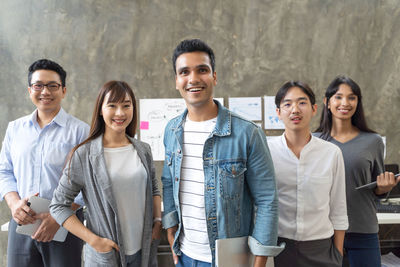 Portrait of smiling colleagues standing at office