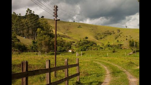 Scenic view of grassy field against cloudy sky