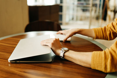 Close-up of woman reading book on table