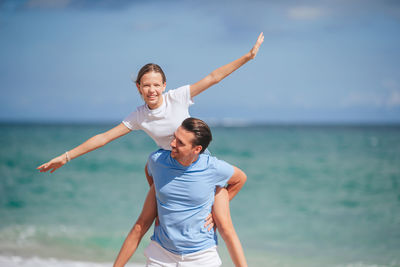 Young woman playing tennis at beach