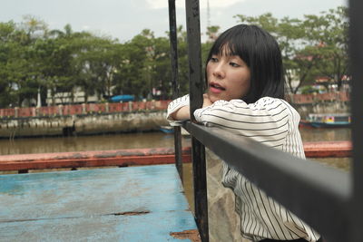 Portrait of woman sitting on seat in park