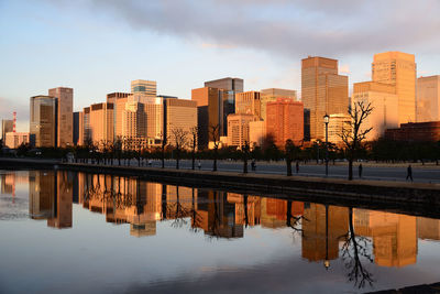 Reflection of buildings in river against sky
