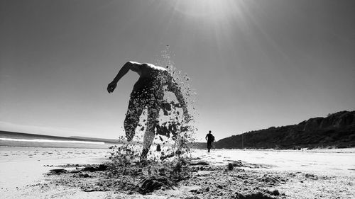 Person standing on beach against clear sky