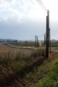 Metal fence on field against sky