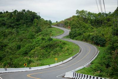 High angle view of road amidst trees against sky