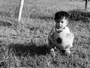 Portrait of boy with ball on field
