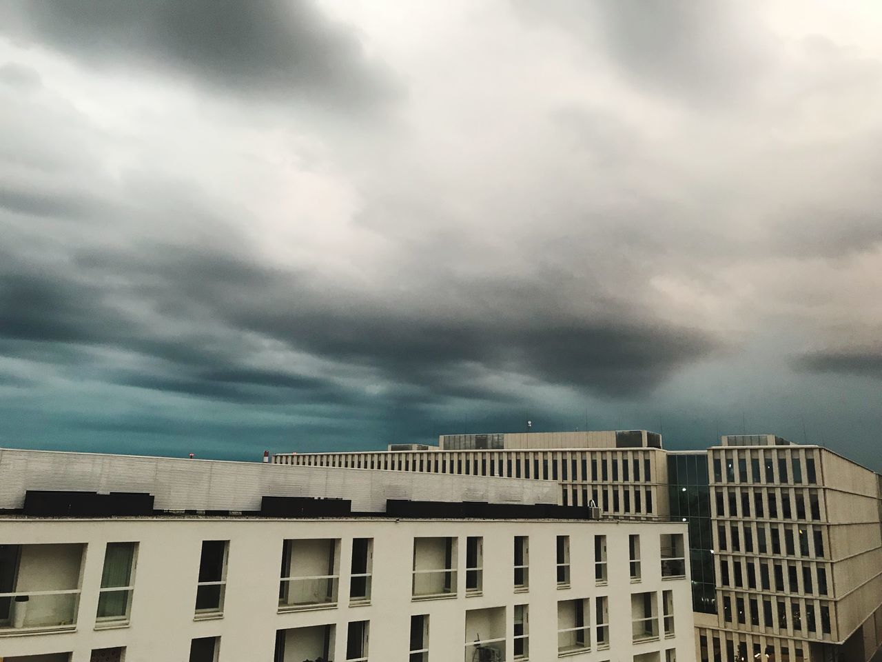 LOW ANGLE VIEW OF RESIDENTIAL BUILDINGS AGAINST CLOUDY SKY