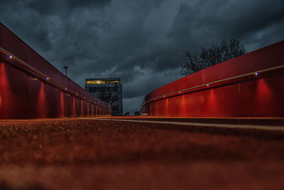 Low angle view of bridge against dramatic sky