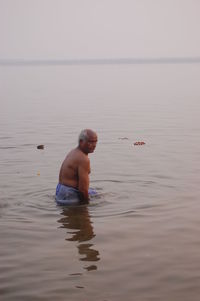 Full length of shirtless man in sea