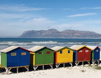 Beach huts by sea against sky