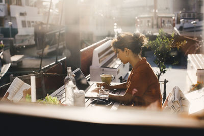 Businesswoman working on laptop in houseboat