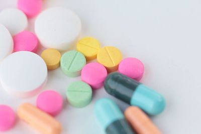 High angle view of colorful pills over white background