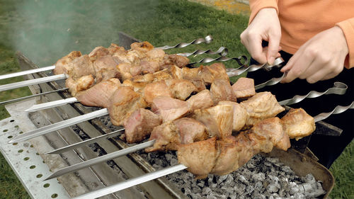 Woman turning skewers on a grill