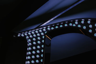 Low angle view of illuminated bridge against blue sky