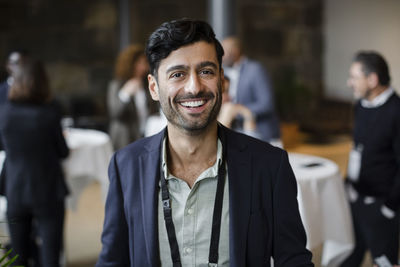 Smiling businessman in blazer at seminar