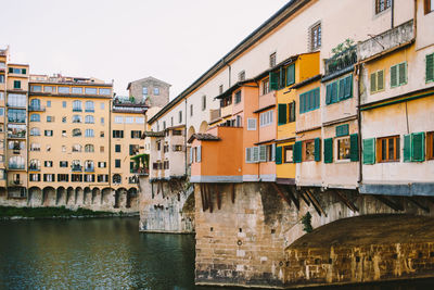 Residential buildings by canal against sky