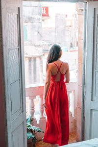 Rear view of woman standing against door