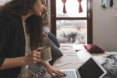 Young woman using laptop at home