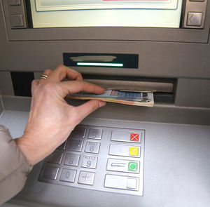 Cropped hand of woman withdrawing cash from atm