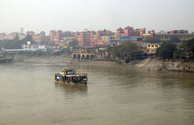 Ferry boat crosses the hooghly river nearby the howrah bridge in kolkata