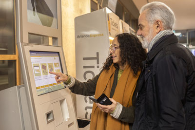Couple buying tickets in ticket machine