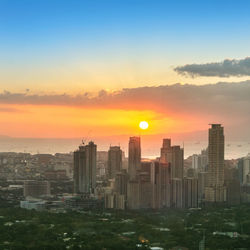 Buildings in city against sky during sunset