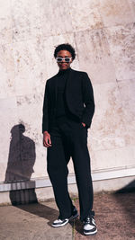 Young man standing against wall