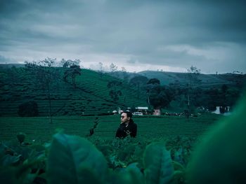 Woman standing on field against sky