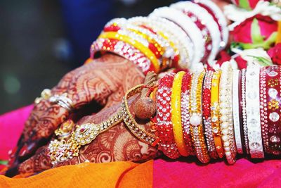 Midsection of bride wearing bangles with henna tattoo