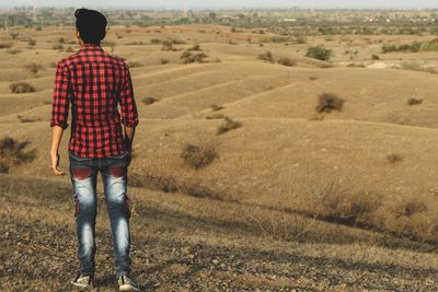 Rear view of man walking on field