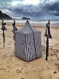 Scenic view of beach against cloudy sky