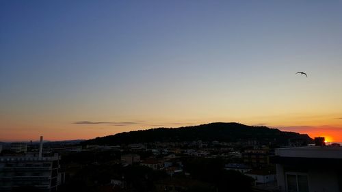 Cityscape against clear sky at sunset