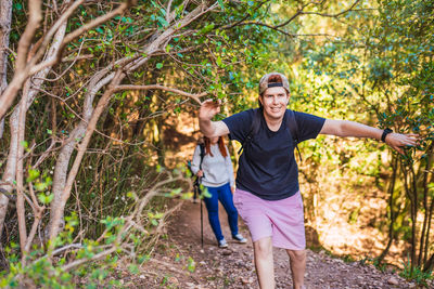 Portrait of young man standing against plants