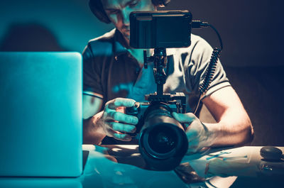 Man holding camera in darkroom