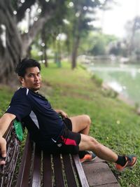 Portrait of mature man sitting on bench in park