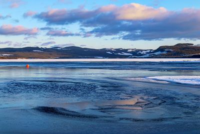 Scenic view of lake against sky during winter