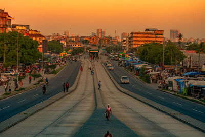 High angle view of people walking on street at sunset 