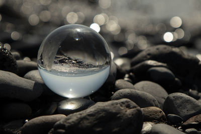 Close-up of crystal bolla and stones on rock