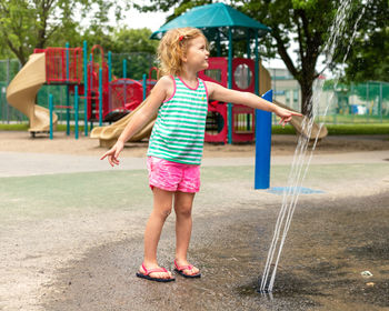 Full length of girl playing in fountain