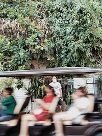 Blurred motion of people against trees