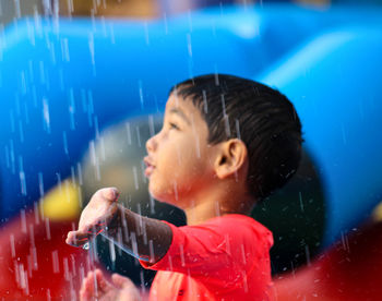 Cute boy touching rain water