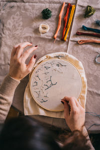 Midsection of person holding paper with text on table